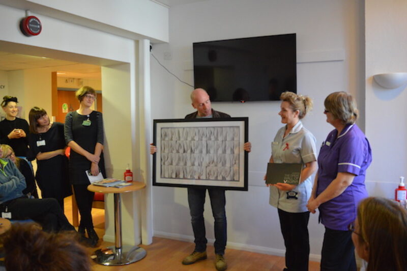 Jamie McCartney presents a signed Great Wall of Vagina photograph at the Brighton SHAC sexual health clinic
