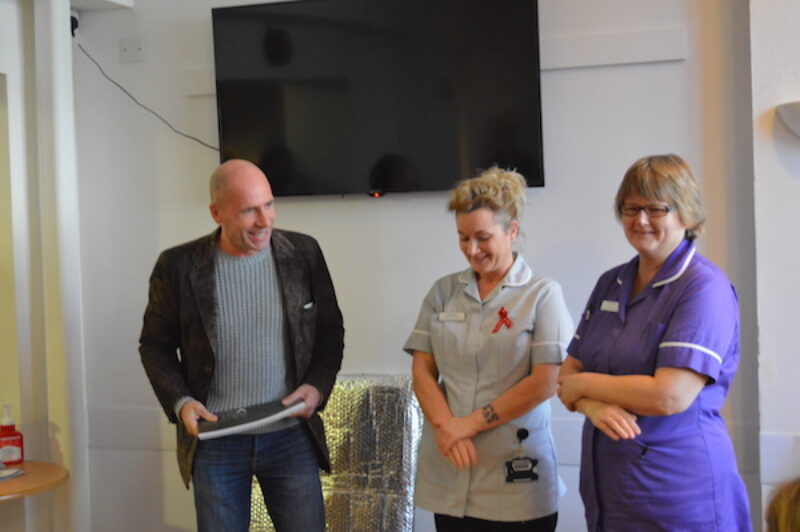 Jamie McCartney presents a signed Great Wall of Vagina book at the Brighton SHAC sexual health clinic